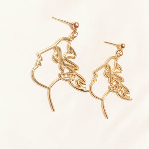 art touching face earrings