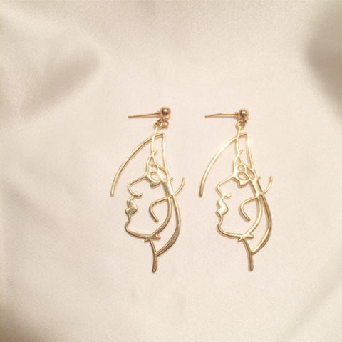 art touching face earrings